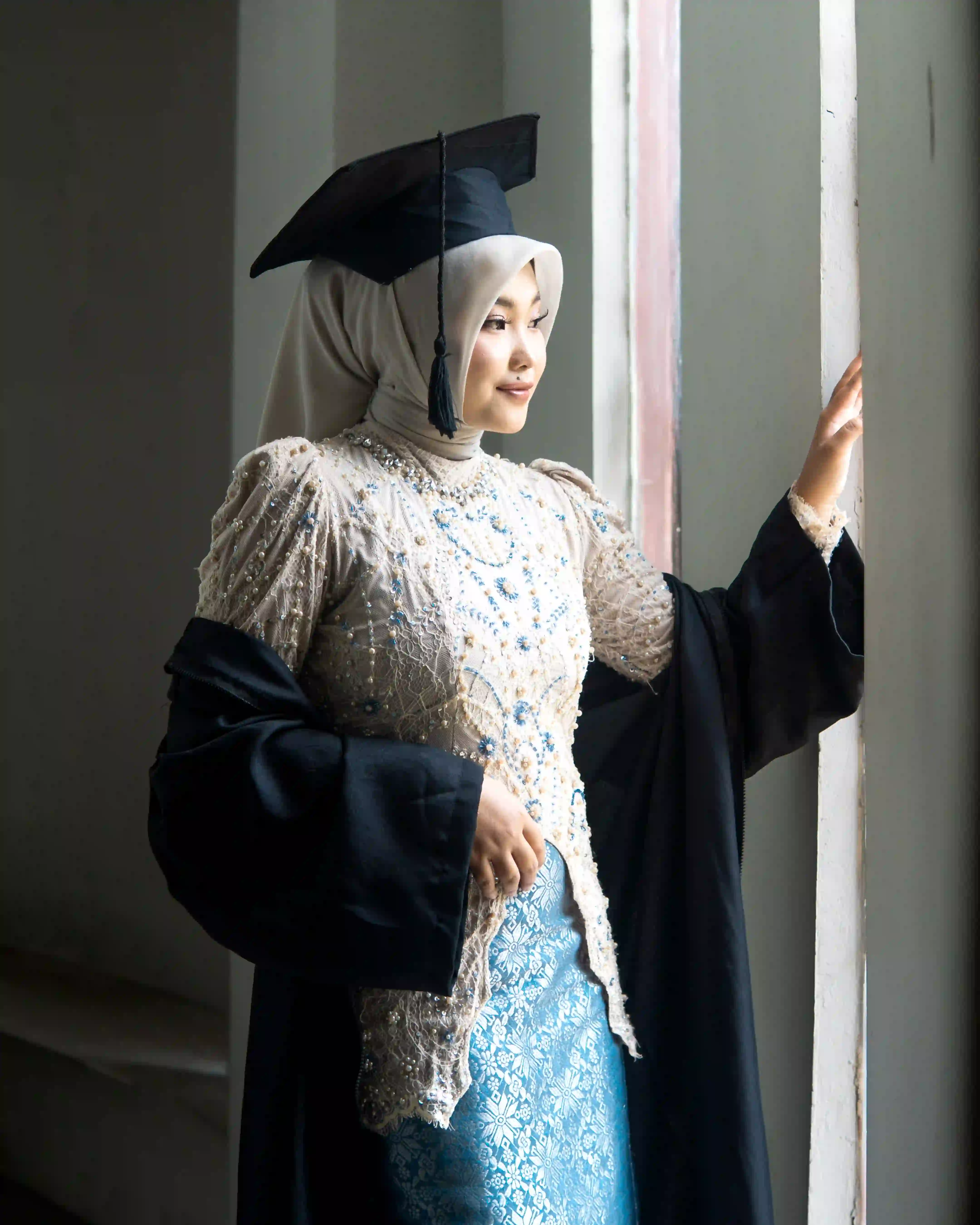Wisudawan Universitas Airlangga UNAIR Surabaya berpose anggun dengan toga dan kebaya di area terbuka kampus