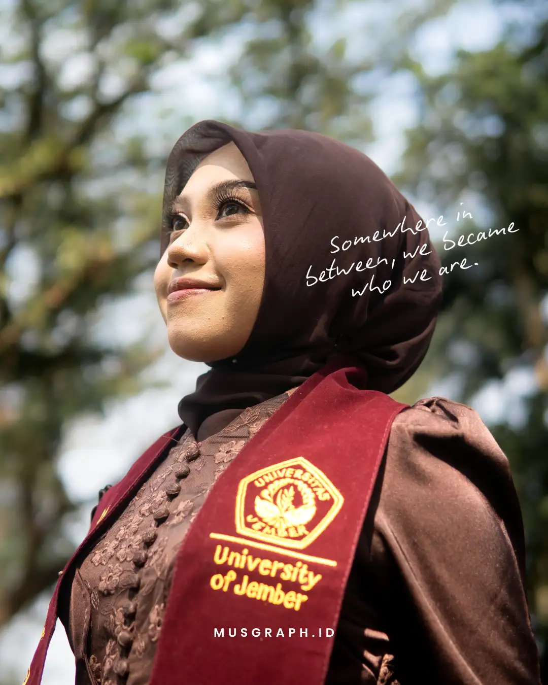 Wisudawan Universitas Jember berpose di taman kampus Sumbersari dengan latar gedung fakultas